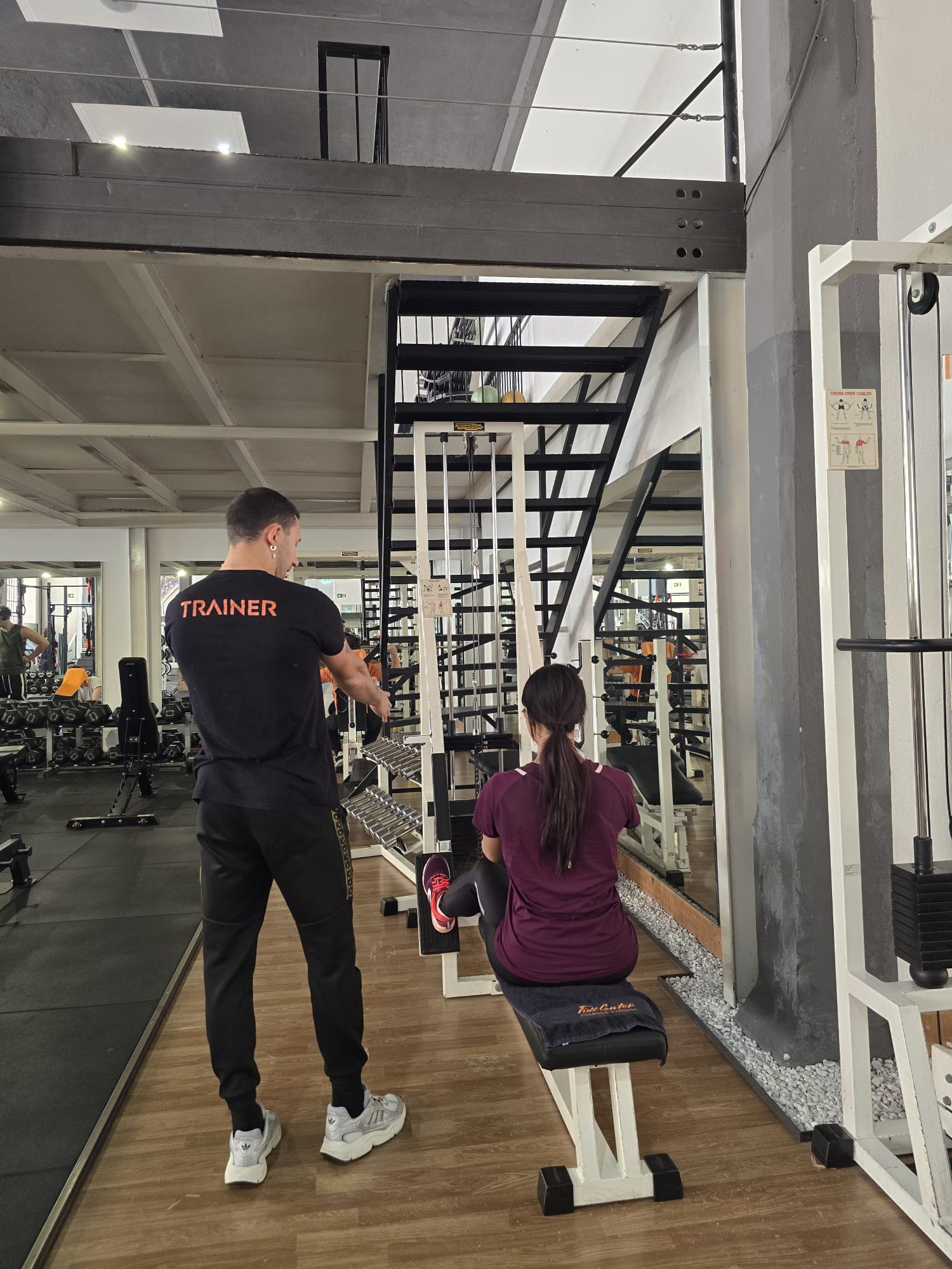 Trainer di Full Center che segue una cliente in allenamento